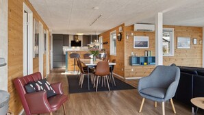 Un intérieur moderne comprenant un coin repas, une cuisine et un espace salon.