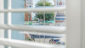 Blick durch ein Fenster mit Spiegelungen von Gebäuden und einer Straßenszene.