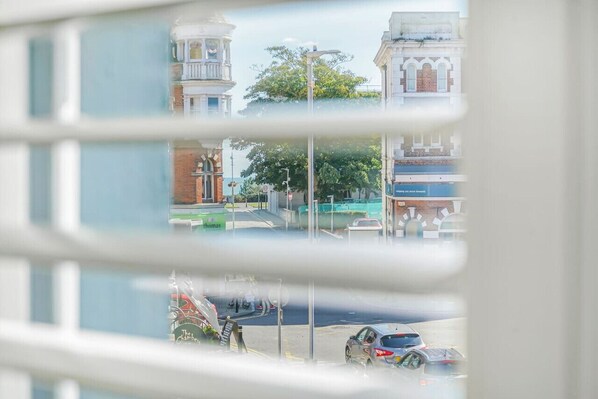 A view through a window with reflections of buildings and a street scene.