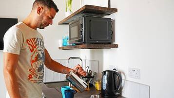 Fridge, microwave, coffee/tea maker, cookware/dishes/utensils