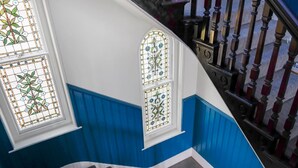 A staircase with blue wainscoting and a wooden handrail. - Eco Aparthotel - Heights Studio (Folkestone)
