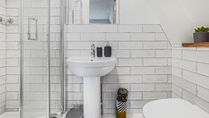 A bathroom with a white sink, a glass shower enclosure, and a toilet. - Eco Aparthotel - Heights Studio (Folkestone)