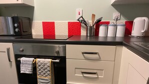 A kitchen with a toaster, oven, and various utensils on the counter.