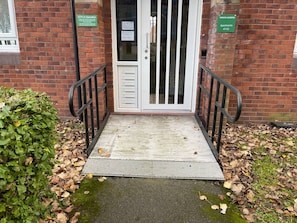 A building entrance with a ramp, a CCTV sign, and a sign for 'Prices Gardens Apartments 47-52'. - Princess Gardens Liverpool Accessible - Infinity (Liverpool)