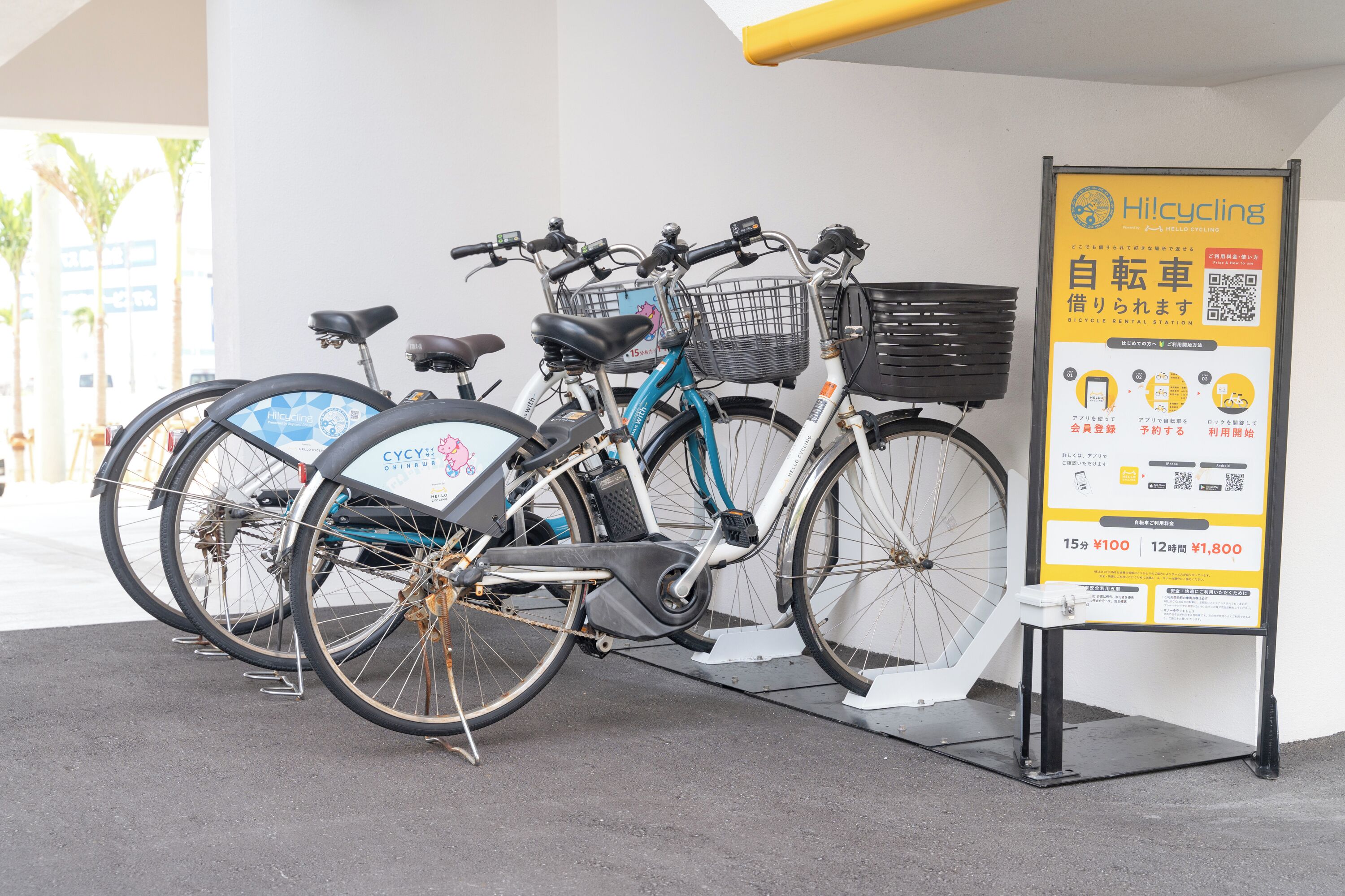 Una estación de alquiler de bicicletas con un cartel y un soporte para bicicletas.