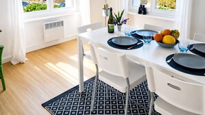 A dining area with a table set for two, a view of the sea, and a hanging plant. - Pretty Breton house with sea view near the beaches and port of Aber Wrach (Landéda)