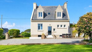 A two-story house with a front porch, a small garden, and a gravel driveway. - Pretty Breton house with sea view near the beaches and port of Aber Wrach (Landéda)