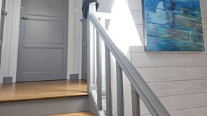 A staircase with wooden steps and a white railing, leading to a closed door. - Pretty Breton house with sea view near the beaches and port of Aber Wrach (Landéda)