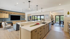 A modern kitchen with a large island, wooden cabinets, and pendant lighting. - Private Paso Robles Vineyard Stay w Pool, Trails & Wine Views | Rancho de Robles (Paso Robles)