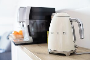 A white electric kettle with the brand name "EMEG" on a kitchen counter. - La Barule (Charols)
