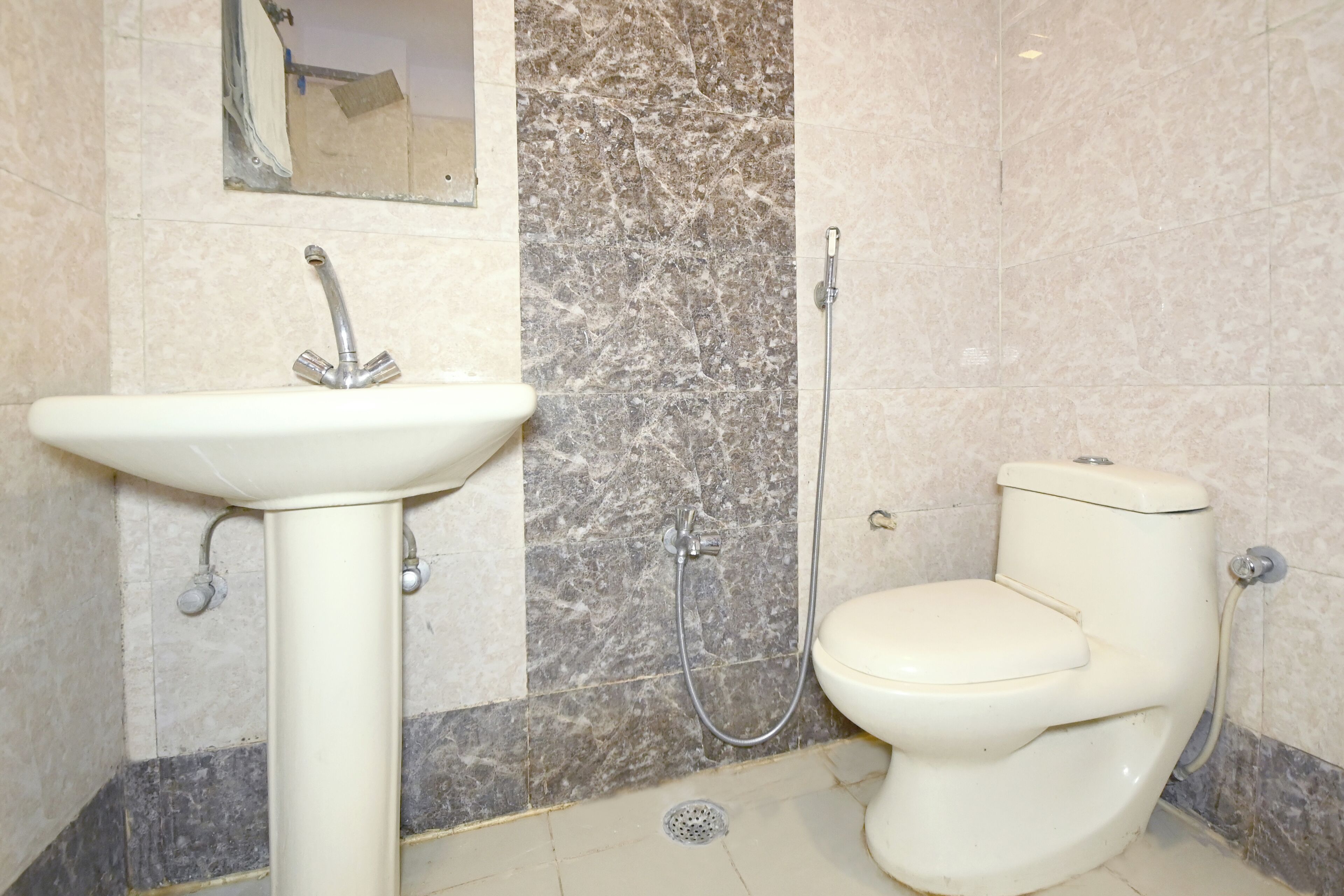 A bathroom with a pedestal sink, a toilet, and a shower.