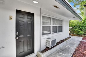 Stylish residence with a front door, windows, and air conditioning unit.
