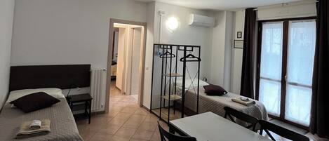 Habitación cuádruple básica | Área de sala de estar | Televisión de pantalla plana de 26 pulgadas con canales digitales