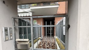 A gated entrance to a building with a tiled floor and a metal gate. - Quadrifoglio affittacamere (Novi Ligure)