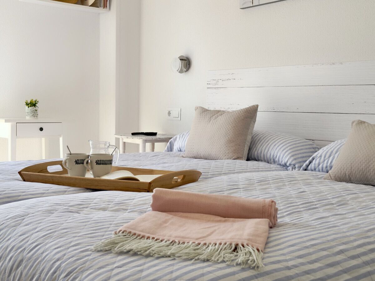 2 dormitorios, tabla de planchar con plancha, ropa de cama