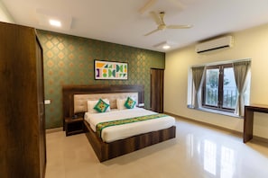 A bedroom with a bed, nightstand, and a ceiling fan. -  Treebo Cranberry Delight (Bengaluru)