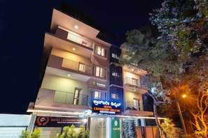 A multi-story hotel with balconies and signage indicating executive rooms available. -  Treebo Cranberry Delight (Bengaluru)
