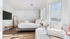 Ein modernes Schlafzimmer mit einem Bett, einer Couch und einer Bank.