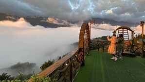 A wooden suspension bridge with a metal walkway, surrounded by misty mountains and a clear sky. - Sapa Mackeno (Sa Pa)