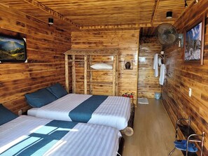 A cabin with two beds, wooden walls, a mounted fan, and a painting. - Sapa Mackeno (Sa Pa)