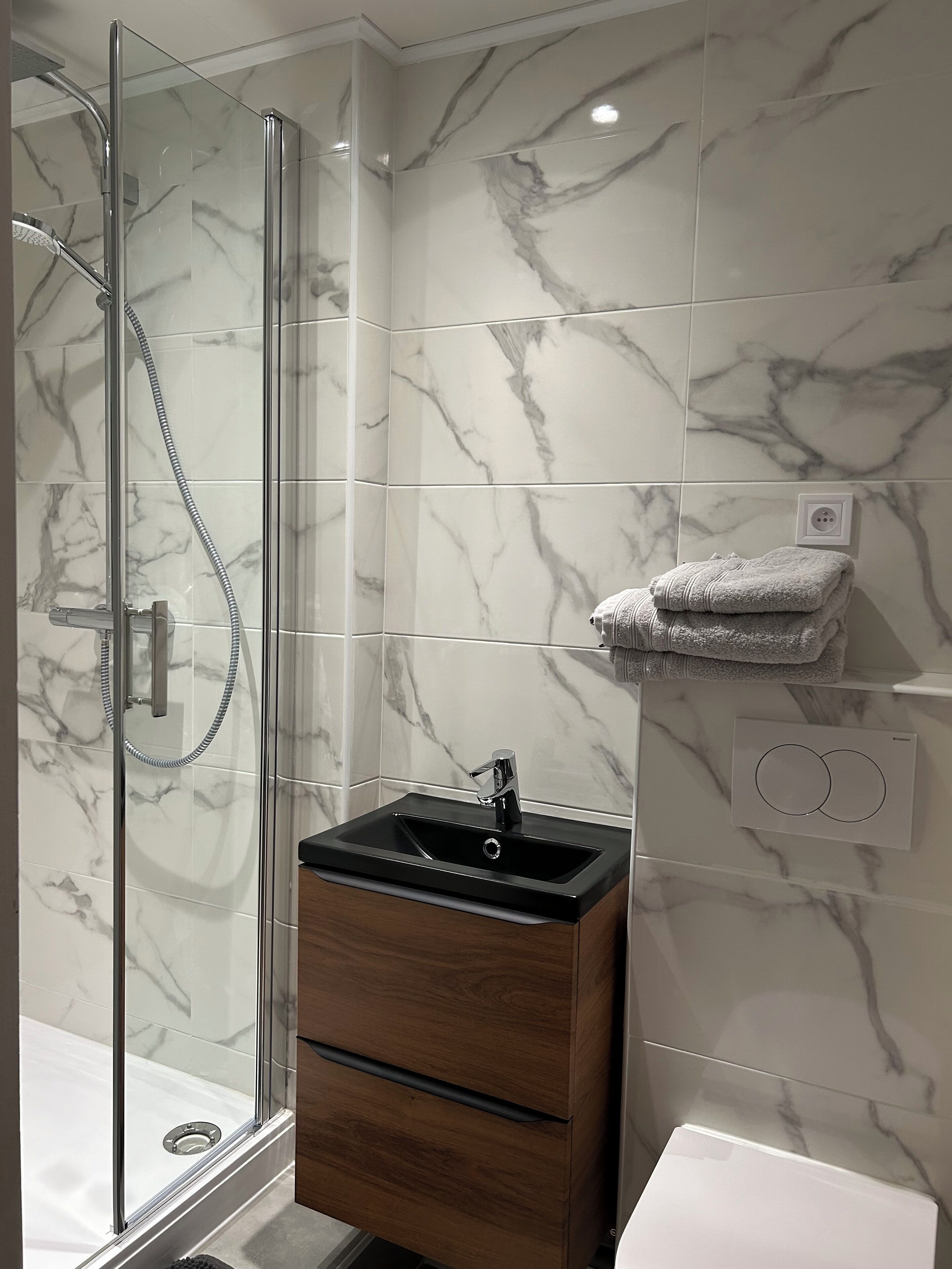 Een douche, handdoeken, toiletpapier