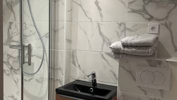 Een douche, handdoeken, toiletpapier