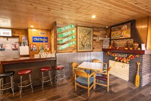 Enjoy a warm and inviting dining experience in this rustic-themed restaurant with a wooden ceiling and walls, featuring a vintage bar and traditional seating.