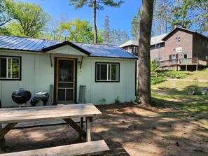 Escape to a serene cabin surrounded by a lush field and trees, where you can grill and enjoy the great outdoors.