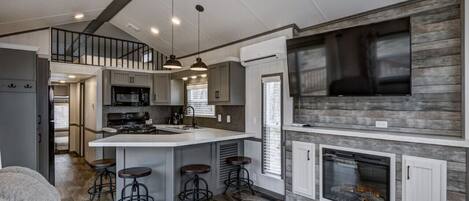 Een koelkast, een microgolfoven, kookgerei, borden en bestek