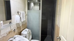 Un baño con ducha, inodoro y lavamanos.