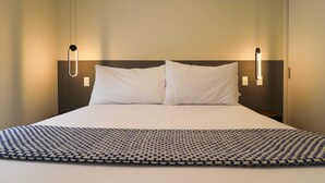 A neatly made bed with a patterned bedspread, two bedside lamps, and a plain wall. - w * | Marvelous 1BR in the Heart of Barranco (Lima)