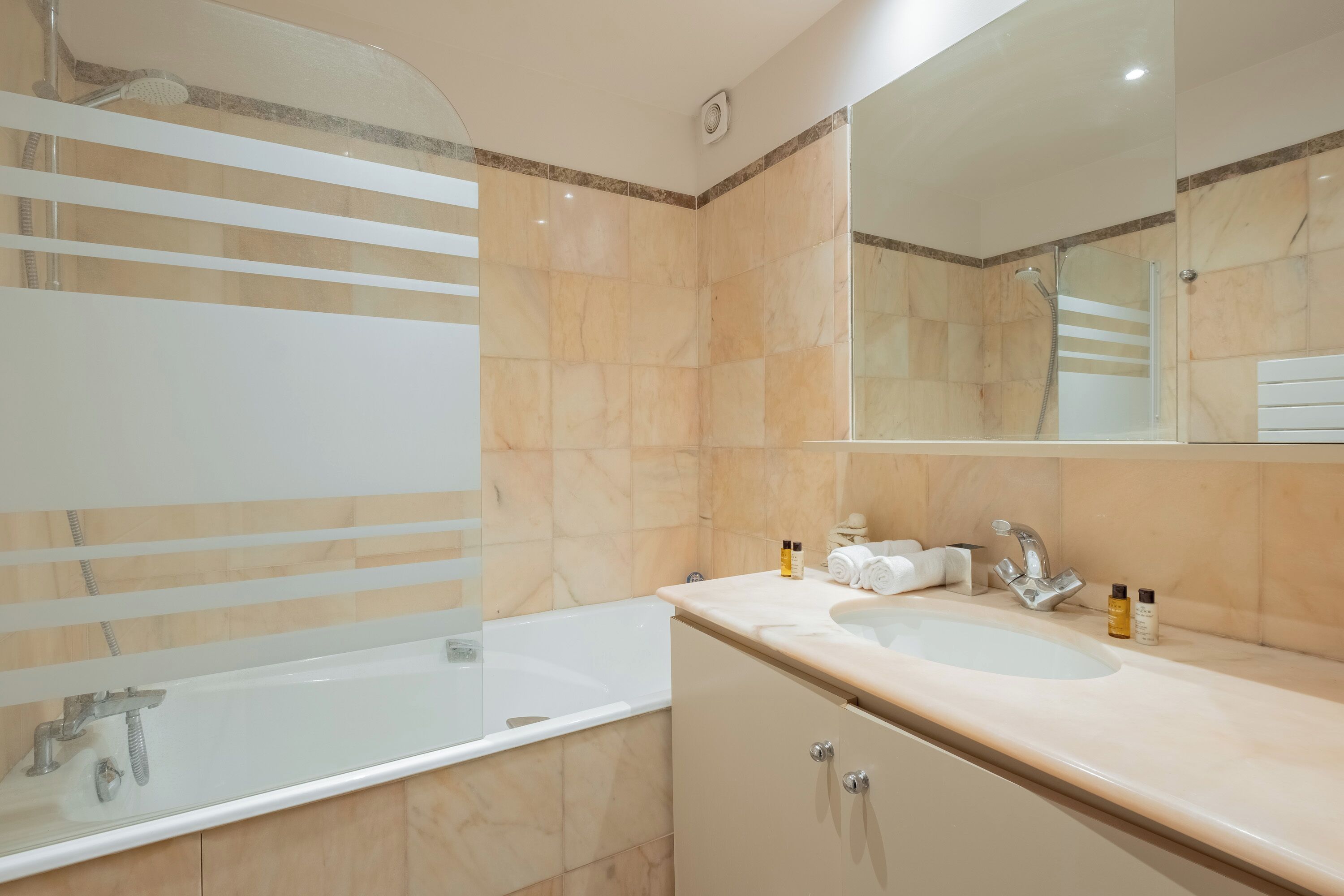 A modern bathroom with a bathtub, a sink, and a shower.