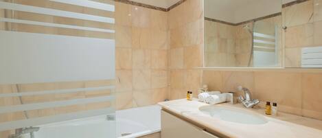 A modern bathroom with a bathtub, a sink, and a shower.