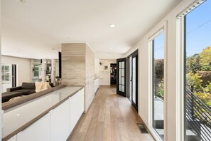 Una cocina moderna con una encimera larga, un horno empotrado y vistas al exterior.