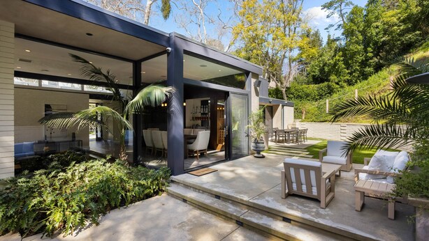A modern house with a patio area featuring outdoor furniture and a garden. - Villa Aman by Stay Awhile Villas (Beverly Hills)