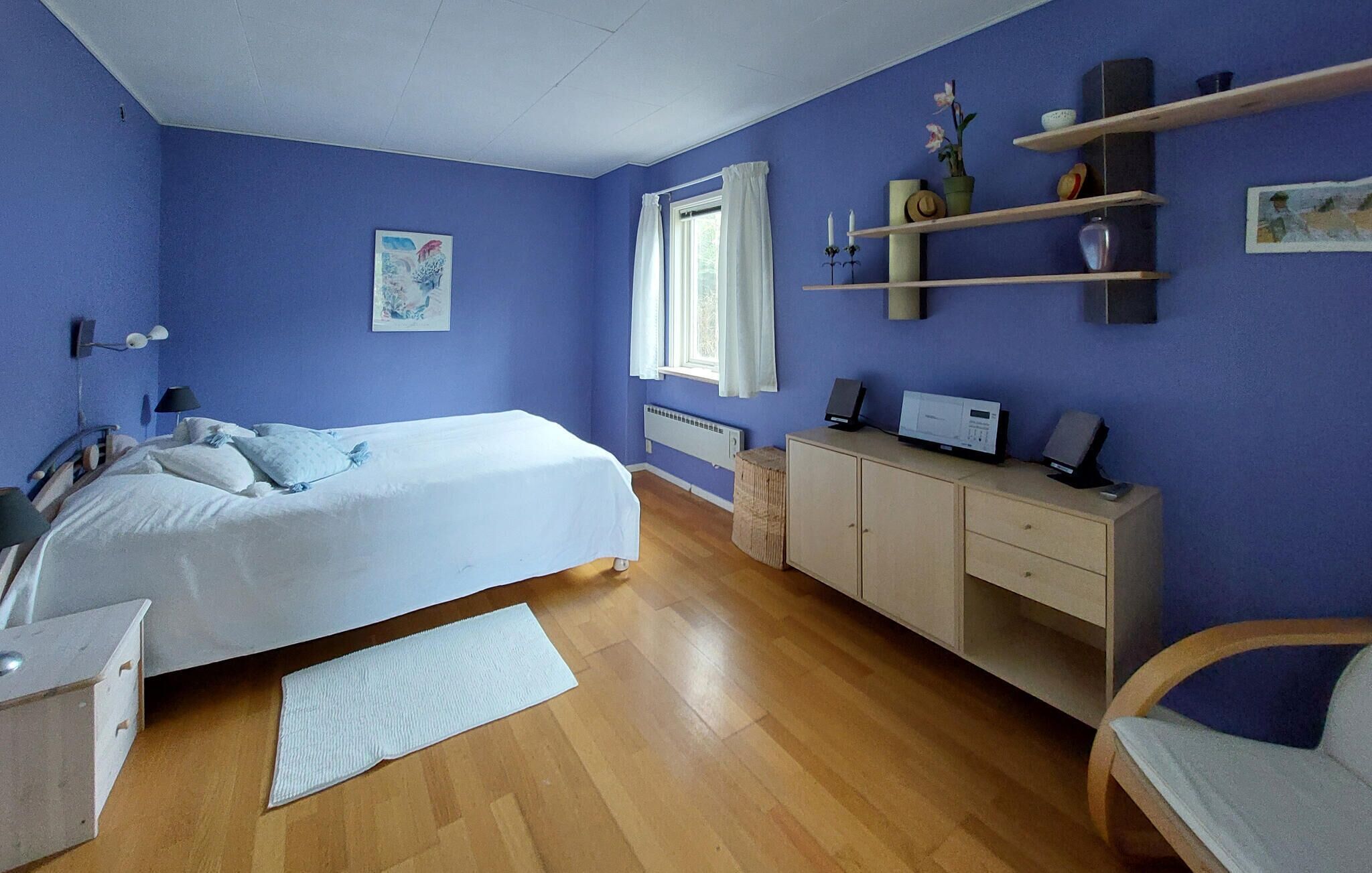 Un dormitorio con cama, escritorio, cómoda y silla.