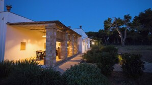 A building with a covered patio area, stone columns, and a pathway leading to a door. - 4 bedroom condo in apulia (Puglia)