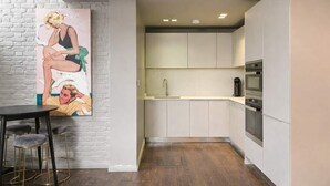 A modern kitchen with white cabinets, a stainless steel oven, and a coffee maker. - Duplex Apartment · Covent Garden · Sleeps 4 (Greater London)
