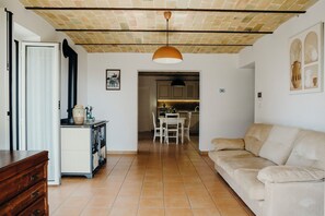A living room with a sofa, a wooden cabinet, and a dining area with a table and chairs.
