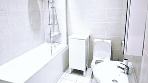 Un baño moderno con bañera, inodoro y ducha.