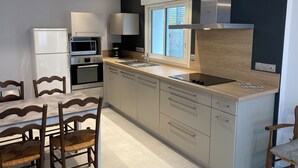 Eine moderne Küche mit Backofen, Mikrowelle und Dunstabzugshaube aus Edelstahl.