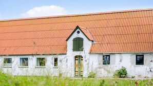 Un edificio blanco con techo rojo y puerta verde.