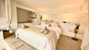 A modern bedroom with a large bed, a bedside table, and a small round table with a plant. - Loft Rodeado de Tranquilidad (Sant Pere de Ribes)