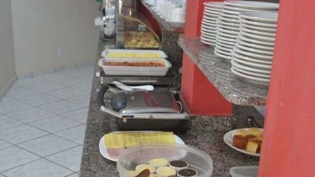 A buffet setup with various food items and utensils. - HOTEL CANCIONEIRO (Sinop)