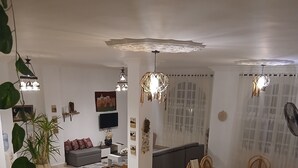 A spacious living area with a sofa, dining table, and chairs, a TV, and decorative plants. - VILLA WITH PRIVATE POOL  (Hurghada)