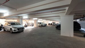 A multi-level parking garage with several cars and motorcycles parked.
