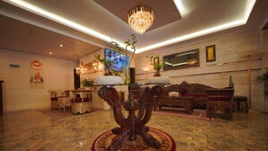 A spacious lobby with a marble floor, a central ornate wooden table, and a chandelier. - Petra Plaza Hotel (Wadi Musa)