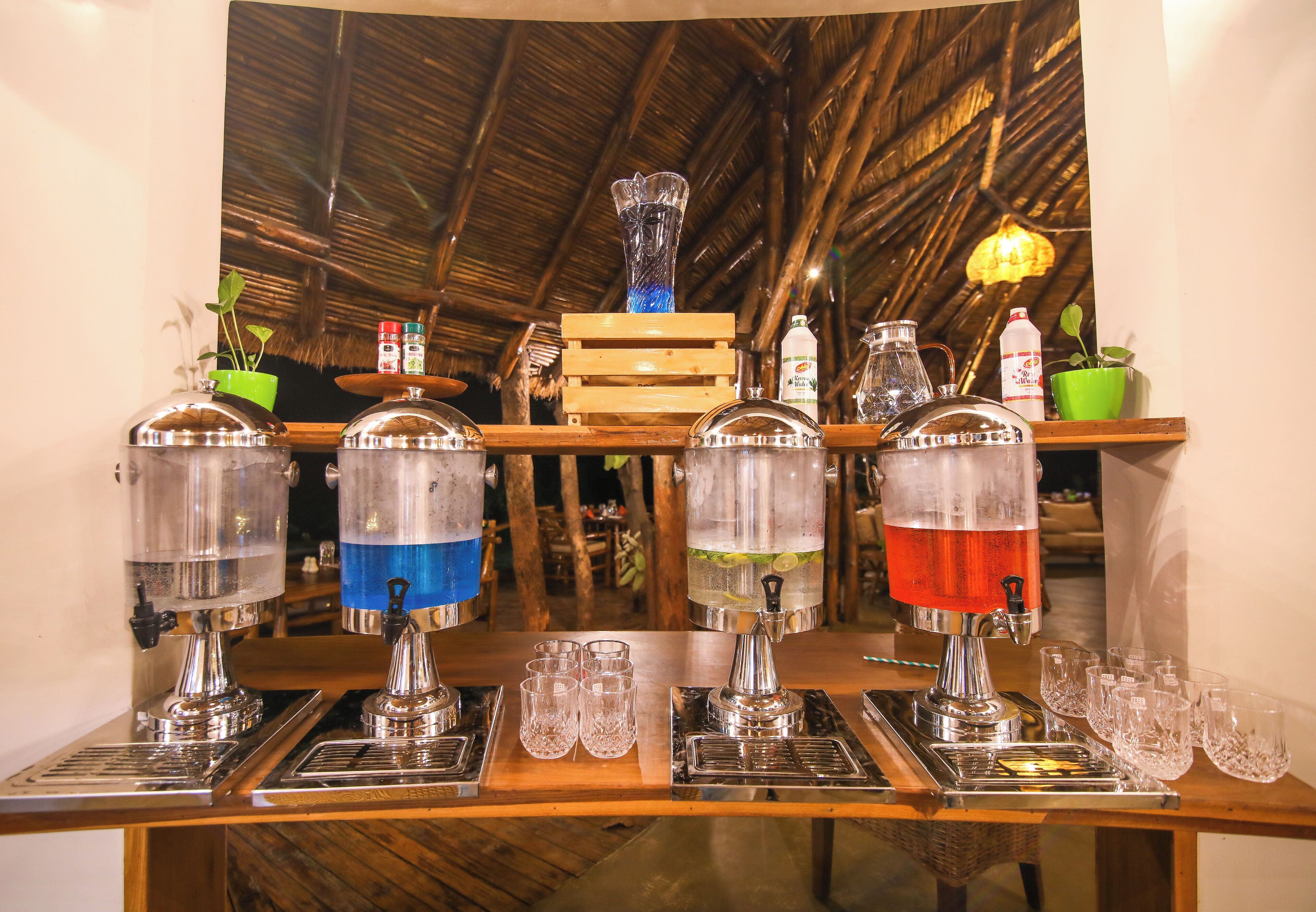 Een bar met verschillende drankdispensers en glazen.
