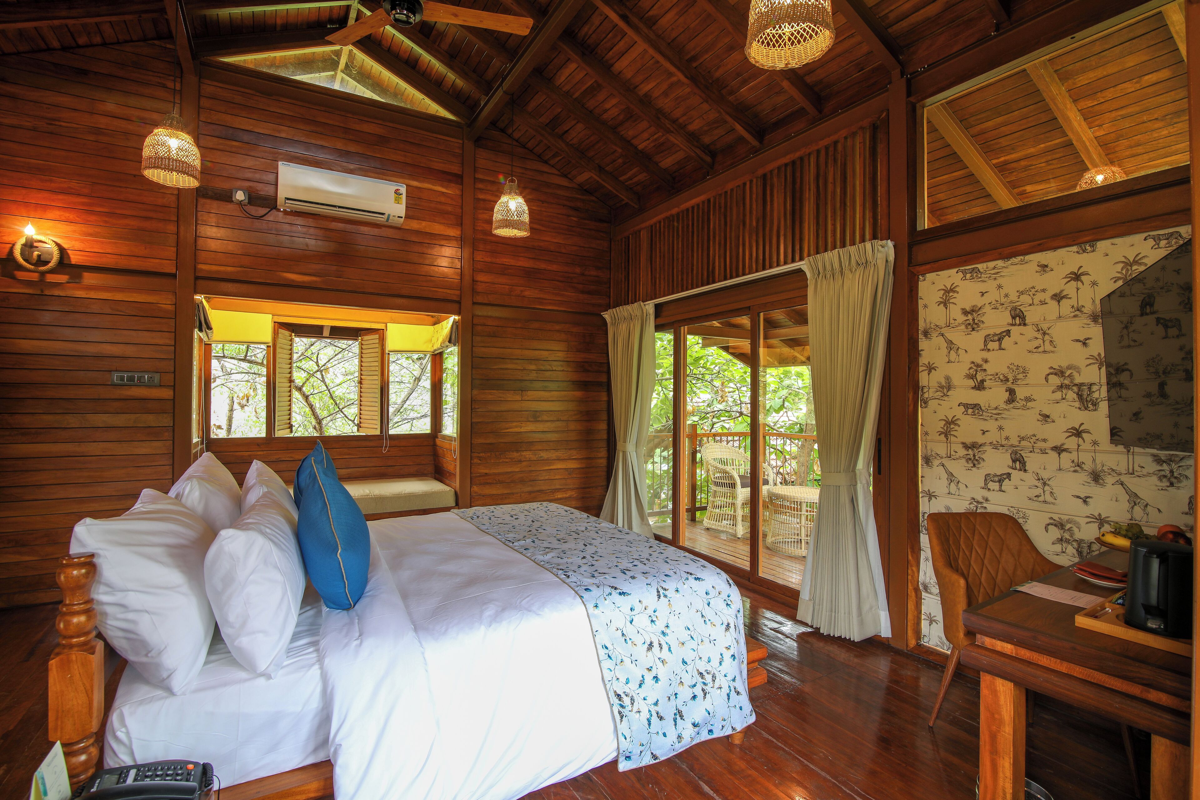 A wooden cabin room with a bed, a table, and a chair.