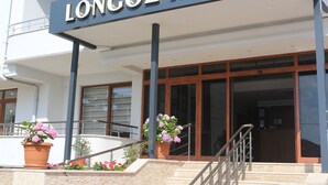 The exterior of the Longozo Hotel with a sign, a staircase, and potted plants. - Longoz Hotel (Demirköy)